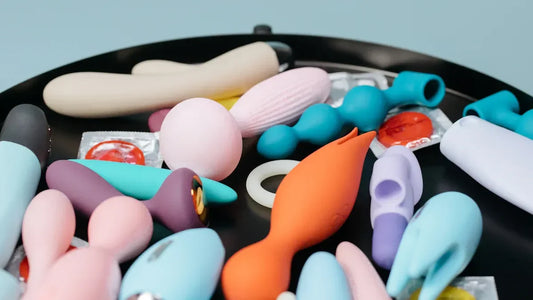 Colorful vibrators and adult toys arranged on a black tray for discreet pleasure.