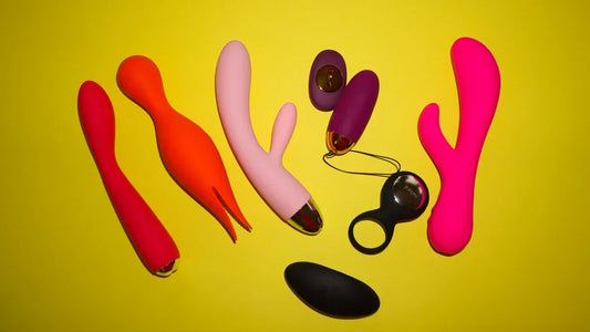 Colorful vibrators and adult toys on yellow background, including G-spot and prostate designs