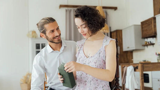 Couple sharing intimate moment with gift box in cozy home setting