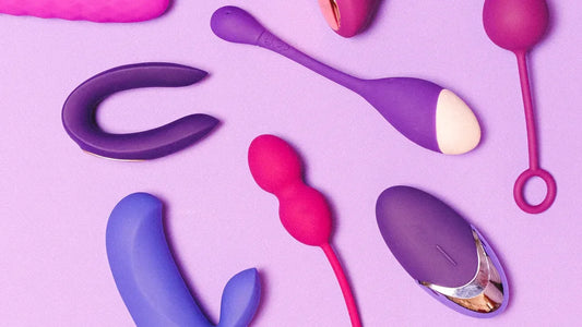 Assorted adult vibrators and sex toys in purple and pink on soft background